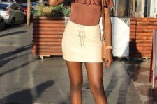 With off the shoulder blouse, white mini skirt, leather bag and patent leather mid calf boots