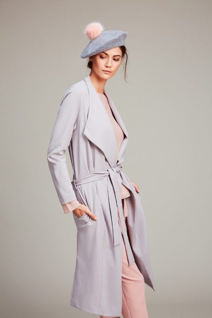 With pale pink blouse, pale pink pants and light gray belted trench coat