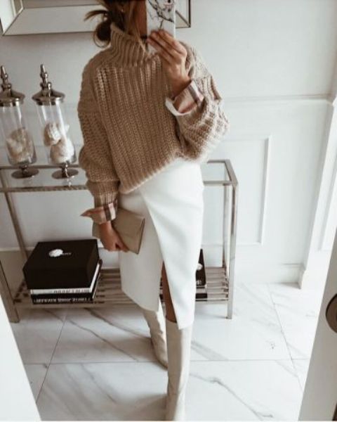 a beautiful and comfy winter work look with a beige chunky sweater, a white wrap midi skirt, white riding boots and a small clutch
