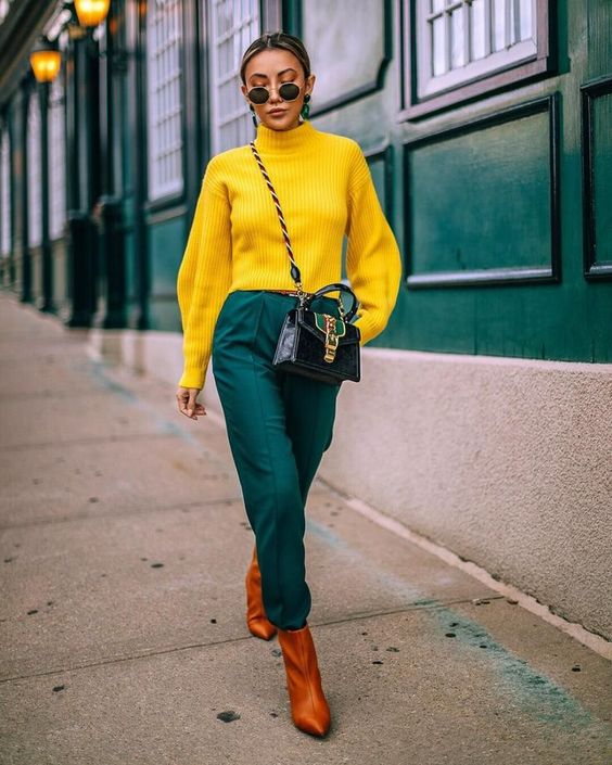 a beautiful jewel toned look with a sunny yellow sweater, dark green trousers, amber boots and a black and green bag