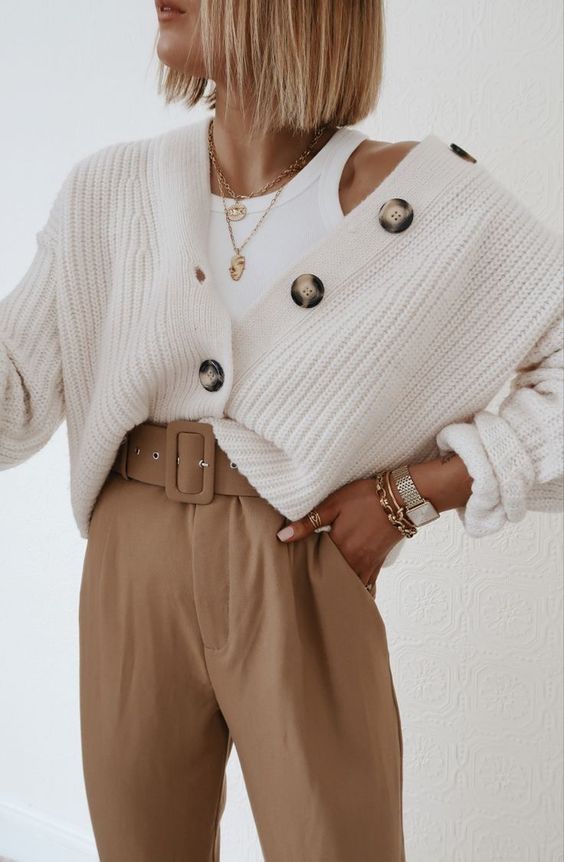 a beautiful neutral outfit with a white top, a creamy chunky cardigan, layered necklaces and beige high waisted pants