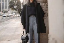 a black ribbed jumper, grey cropped trousers, black zip boots, a black coat and a catchy black bag