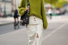 a bold and super trendy winter work look with a green chunky sweater, a white leather midi skirt with pockets, white tall boots and a black bag