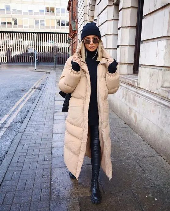 a bold contrasting outfit in black, with a tan puffer coat that refreshes the look and makes it more eye catchy