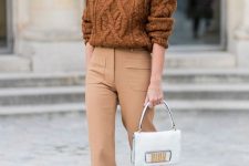 a brown patterned oversized sweater, tan high waisted trousers, white boots and a white bag for a chic look