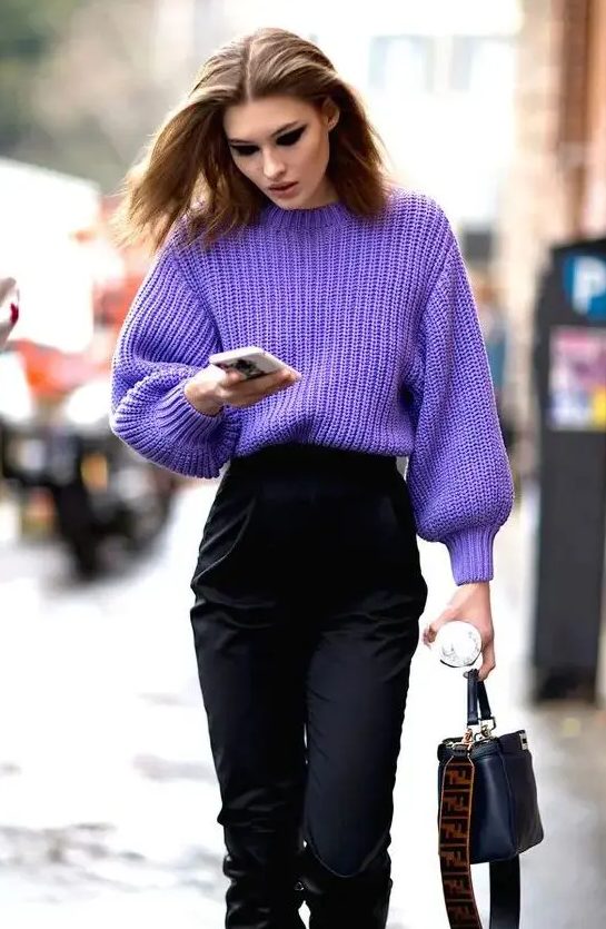 a chic and trendy outfit with a purple high neck chunky knit sweater, black high waisted trousers and a black bag