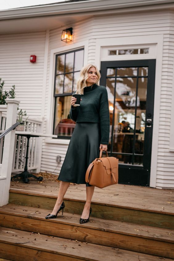 a chic monochromatic dark green outfit with a jumper, a slip midi skirt, black printed shoes and a camel bag
