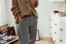 a cozy outfit with a white top, a beige cardigan tucked into blue jeans, white sneakers and a red belt