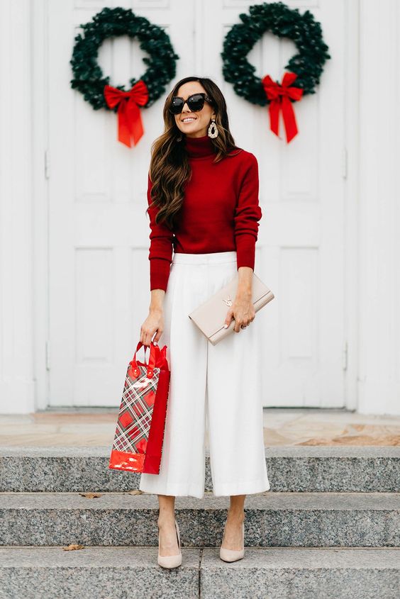a deep red turtleneck, white culottes, nude shoes and a clutch plus statement earrings compose a great party or work outfit