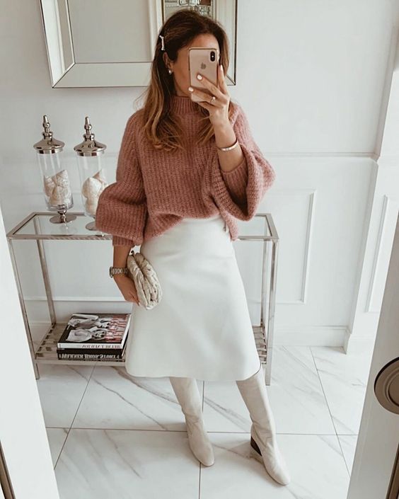 a girlish winter work look with a pink chunky sweater, a white A-line midi skirt, white boots and a clutch is a lovely and cool outfit