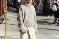 a grey oversized turtleneck sweater, a creamy fuzzy wrap midi skirt, tan shoes and a small clutch for a minimal winter work look