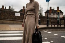 a grey ribbed turtleneck, a matching grey midi skirt, black hiking boots and a black bag for a minimalist winter work look