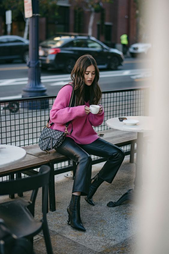a hot pink sweater, black leather trousers, black booties, a saddle printed bag for a bright and cool winter look