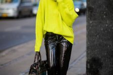 a jaw-dropping look with a neon green oversized sweater, black leather pants, neon green shoes and a printed tote
