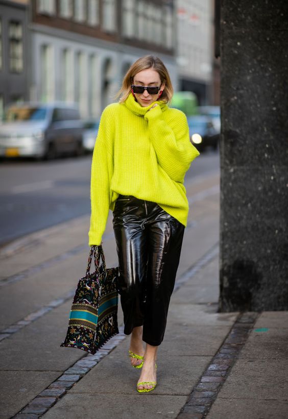 a jaw dropping look with a neon green oversized sweater, black leather pants, neon green shoes and a printed tote