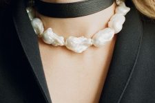 a large baroque pearl choker paired with a black leather one creates a bold contrasting look that will catch all the eyes