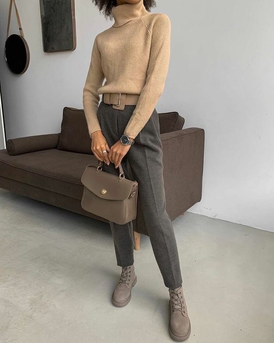a lovely and laconic winter work look with a beige turtleneck sweater, grey trousers, dove grey boots, a grey bag and a statement belt
