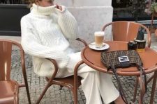 a lovely and refiend outfit with a white chunky patterned oversized sweater, matching trousers, black strappy shoes and a printed bag