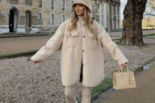 a pretty neutral winter look with a turtleneck, leather leggings, a faux fur shirt jacket, a bag and a bucket hat