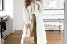 a refined neutral winter look with a turtleneck, leather leggings, white boots, a midi coat and a neutral bag is wow