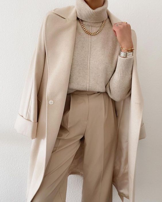 a refined total neutral outfit with a creamy sweater, tan trousers, a creamy coat and lovely and timeless accessoies