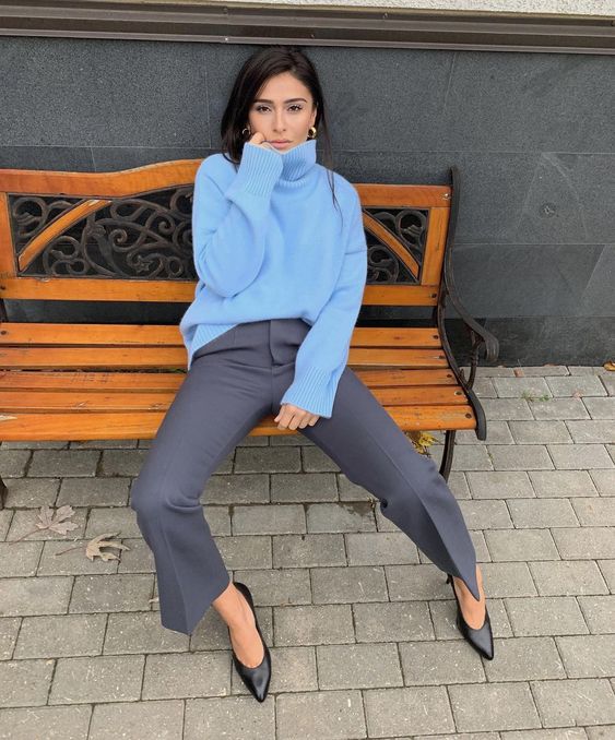 a simple and cool winter work look with a sky blue turtleneck sweater, grey trousers, black shoes and gold hoop earrings