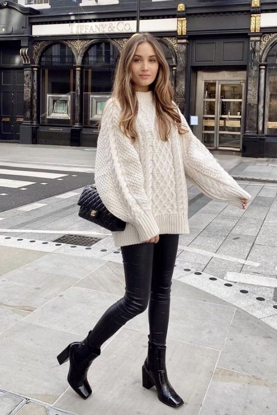 a simple winter work look with an oversized white patterned sweater, black leather leggings, black boots and a black bag