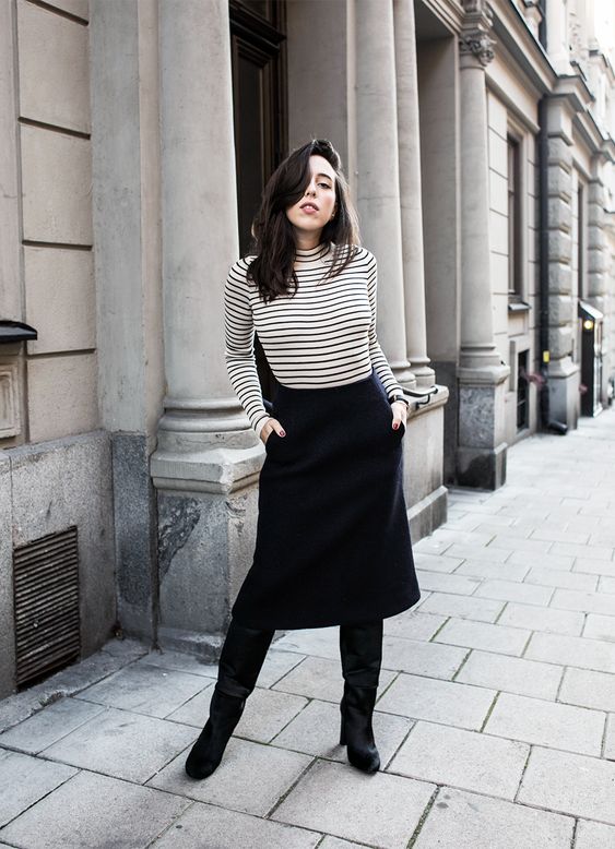 a striped turtleneck, a black midi skirt with pockets, black boots for a super chic and girlish work look