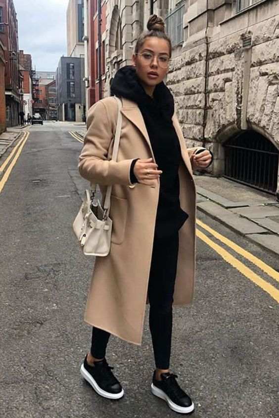 a stylish look with a black hoode, leggings and sneakers, a beige midi coat and a neutral bag is comfy and lovely