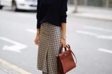 a stylish winter work outfit with a navy turtleneck sweater, a plaid asymmetrical skirt, black boots and a burgundy bag