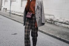 a stylish work outfit with a delicate holiday touch – a rust jumper, black and tan plaid trousers, rust boots, a grey blazer and a burgundy bag