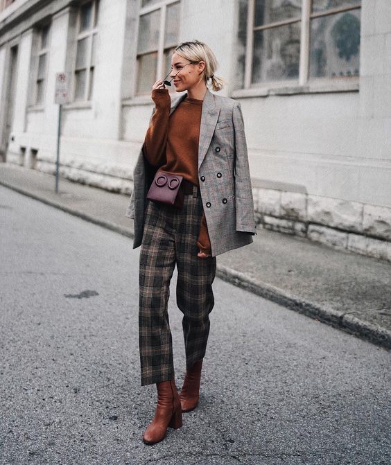 a stylish work outfit with a delicate holiday touch - a rust jumper, black and tan plaid trousers, rust boots, a grey blazer and a burgundy bag