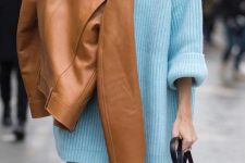 a super oversized light blue turtleneck sweater, beige trousers, a tan leather jacket and a black bag for a statement