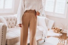 a white oversized turtleneck sweater, tan high waisted trousers, tan shoes and statement earrings for a chic work look