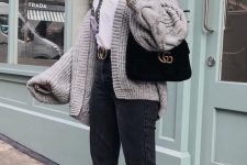 a white shirt, black cropped jeans, a grey oversized and chunky cardigans, white sneakers and a black velvet bag