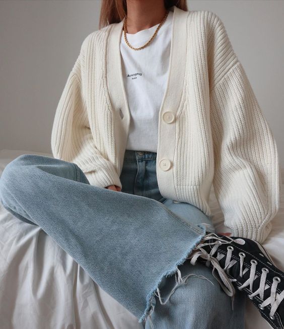 a white t shirt, a white chunky cardigan, light blue jeans, black sneakers and a statement chain for a casual look