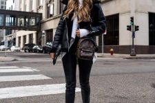 a white turtleneck sweater, black leather leggings, boots, a black shearling coat and a brown backpack