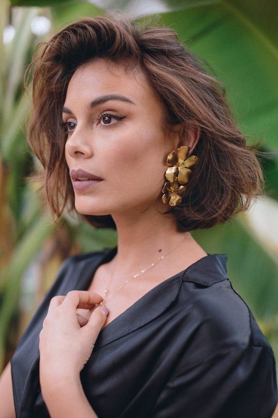 an elegant look for a special occasion with oversized gold flower earrings, a delicate necklace and a black dress just wows