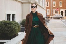 an emerald shirtdress with a pleated skirt, a brown belt, brown boots and a midi coat plus a beige bag