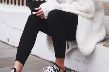 an everyday look with a white tee, black leggings and sneakers and an oversized chunky knit cardigan on top is amazing as a casual look