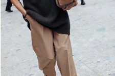 an oversized black sweater, beige culottes, brown tall boots and a brown faux fur bag for a comfy winter look