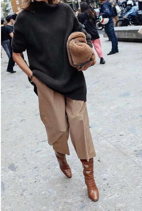 an oversized black sweater, beige culottes, brown tall boots and a brown faux fur bag for a comfy winter look