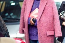 an oversized purple patterned turtleneck sweater, blue jeans, a pink coat and a blush clutch