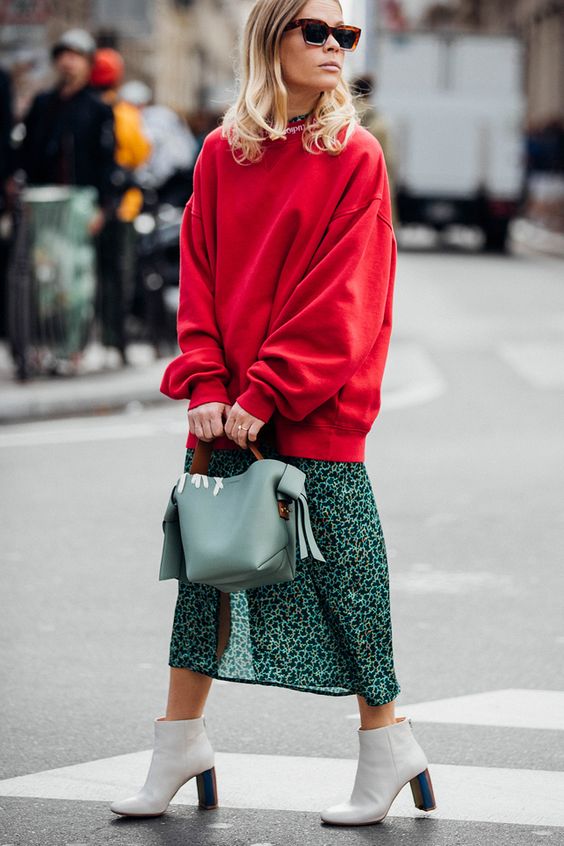 an oversized red sweatshirt, a green midi skirt, white boots and a light green bag for work