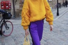 an oversized yellow turtleneck sweater, purple trousers, green embellished shoes, a yellow pearl bag