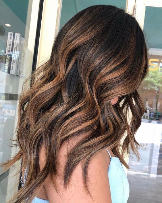 beautiful long dark brown hair with rich caramel highlights and waves for a more eye catchy and cool look