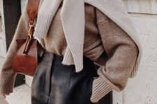 black high waisted trousers, a beige cashmere sweater and an additional creamy one on the shoulder and a brown bag