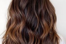 chocolate brown wavy hair with very subtle touches of caramel balayage is a beautiful solution to rock