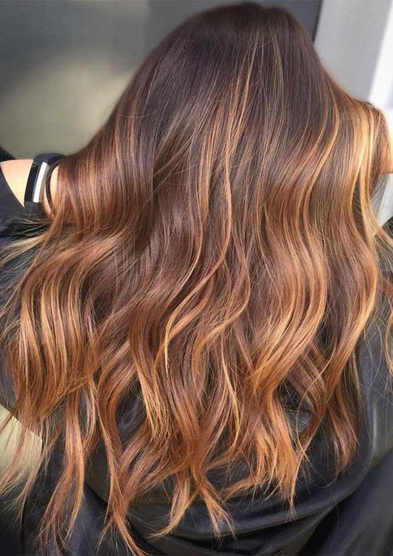 dark auburn hair with waves and lovely bold caramel balayage for a catchy and chic look just wows