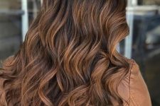 long dark wavy hair with caramel highlights and dark roots is beautiful and chic and looks gorgeous